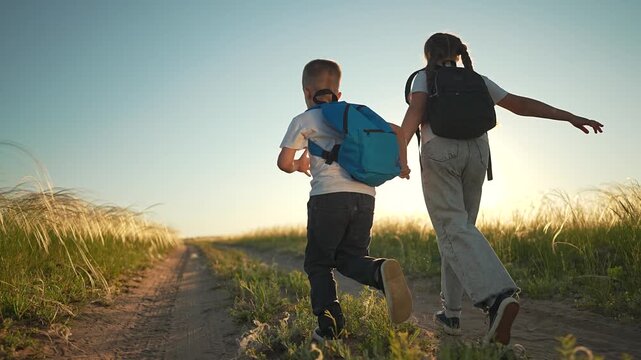 Girl and boy walk on nature path holding hand. Field shines under summer sun. Happy sibling steps on outdoor trail. Boy girl enjoy walk together. Nature offers peace. Hand joins sibling on warm field.