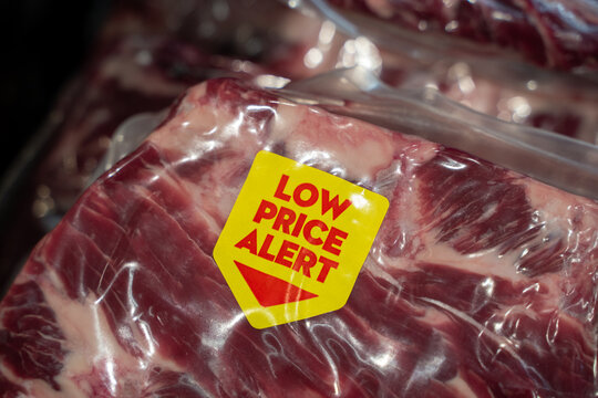 Close up of discounted meat package with low price alert label.