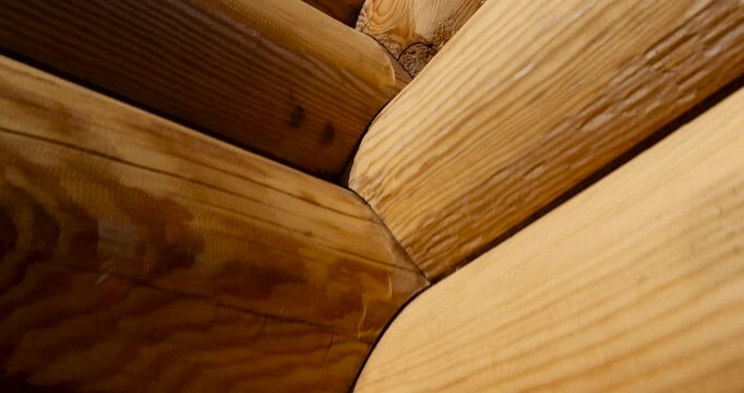 A wooden log cabin of a woody shade, a natural log cabin is an element of the wall of a chopped hut in the open air