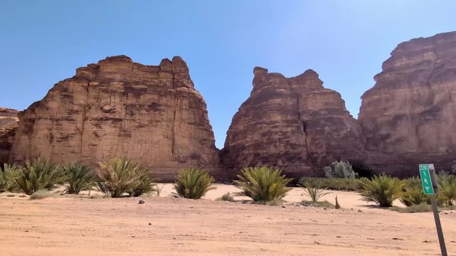 View from a moving vehicle's window showing the rocky mountains in a wild open space at Alula Saudi Arabia on a sunny day