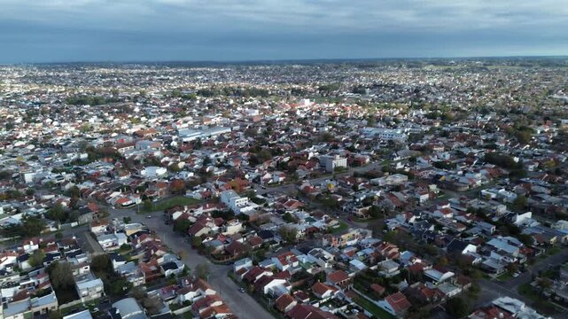 drone video of a city during the day, stadium and playground,
dramatic sky and sea horizon, aerial shot of a village by the ocean,