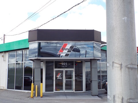 Gatineau, Quebec, Canada &ndash; May 7, 2026: The commercial entrance of "Dma Construction" at suite 100 features large reflective windows under a dark overhang at 901 Bd Saint-Joseph suite 100.