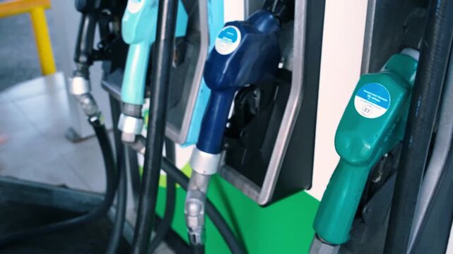 Petrol Pump Guns Dispensing Fuel at Modern Gas Station with Digital Display Screen in 4K Ultra HD footage.
