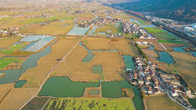 Aerial view of rural village surrounded by farmland and ponds