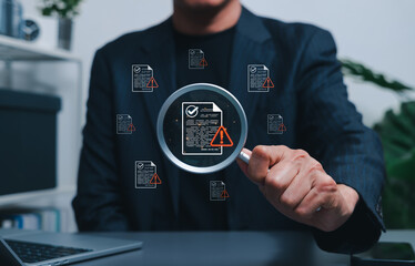 Document risk review and compliance audit warning concept. Businessman using magnifying glass to...