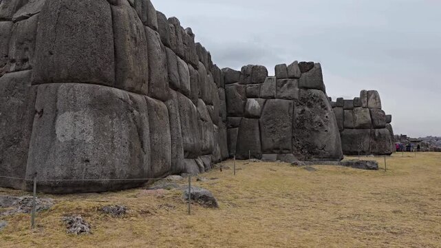 Sacsayhuam&aacute;n, Cusco, Peru - 20 June 2024. Panning shot of the monumental Inca stone walls, featuring large interlocking masonry blocks with irregular shapes fitted together without mortar.