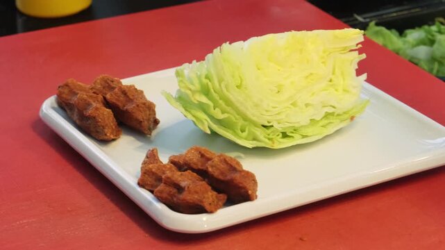 A detailed close up video of traditionally shaped hand squeezed cig kofte portions neatly arranged on a modern square plate, showcasing authentic spicy Turkish street food.
