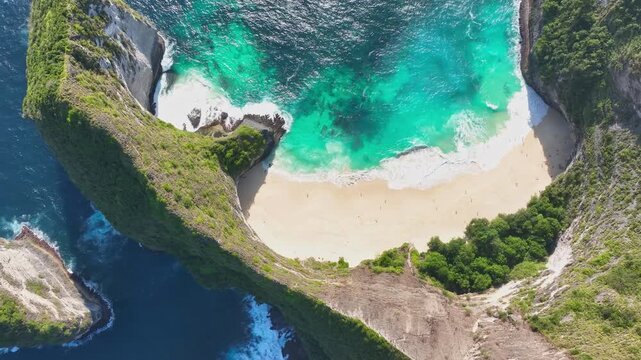 Drone view of Gelingking Beach on Nusa Penida Island, Indonesia, bathed in the sparkling midday sun and overlooking the turquoise sea.