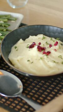 Vertical video: Panning camera revealing home table meal, showcasing salad, mash, bottles, chicken