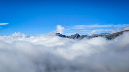 Mountain peaks above a sea of clouds under clear blue sky © F#ck yeah! Go you!