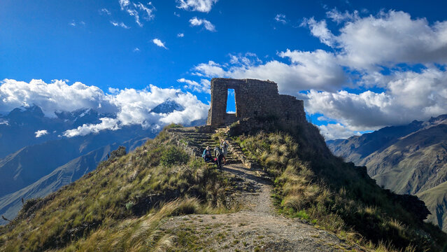 Ancient Inca ruins on a mountain ridge in Peru under blue sky