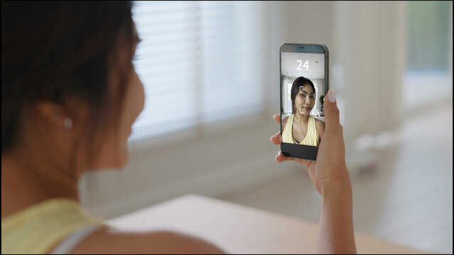 Asia people young adult woman using digital device screen phone scan age app look at camera smart bioage face online test agentic AI. Asian female Health care facial skin anti aging beauty tracker.