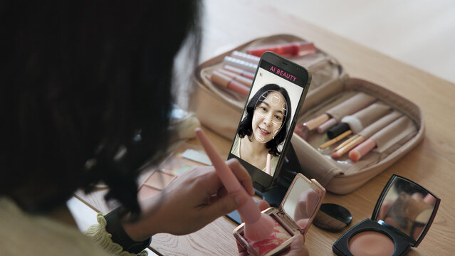 Asia people young gen z female happy smile enjoy phone apply selfie screen makeup blush virtual AI tech scan face app AR mixed augmented reality future beauty smart iot skin care help guide advice.