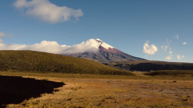 Cotopaxi Volcano at sunset over Andean hills and grasslands