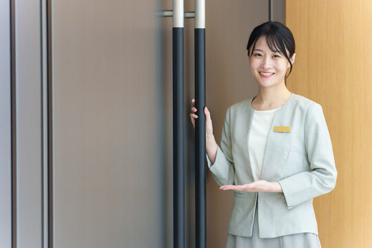 ドアの前に立つ受付の女性