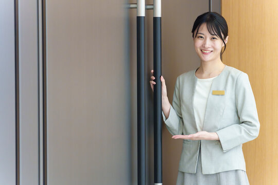 ドアの前に立つ受付の女性