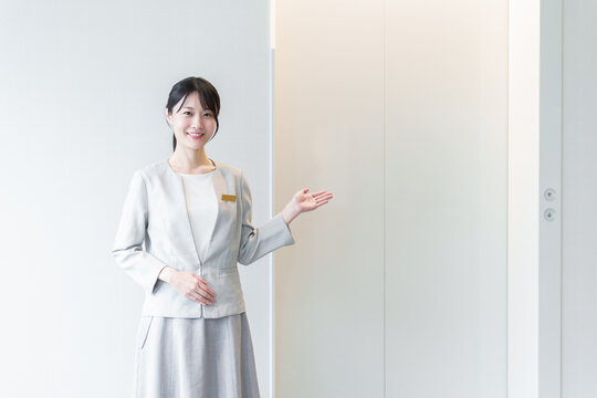 エレベーターの前に立つ女性　エレベーターガール