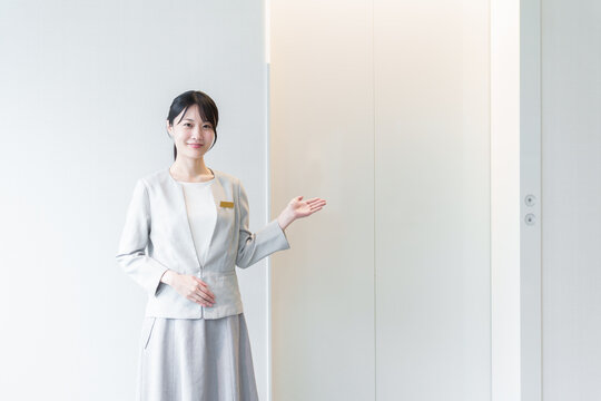 エレベーターの前に立つ女性　エレベーターガール