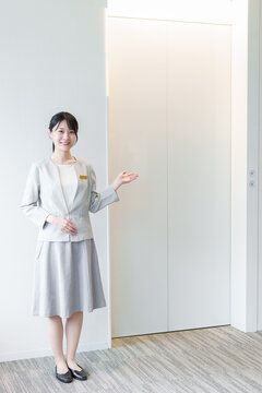 エレベーターの前に立つ女性　エレベーターガール
