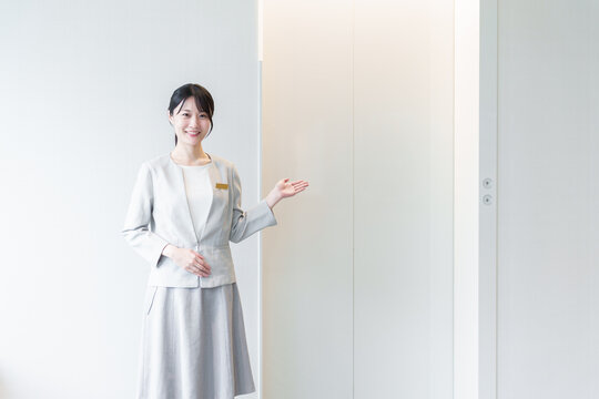 エレベーターの前に立つ女性　エレベーターガール
