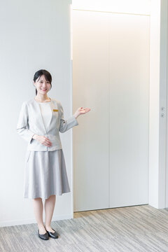 エレベーターの前に立つ女性　エレベーターガール