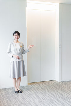 エレベーターの前に立つ女性　エレベーターガール