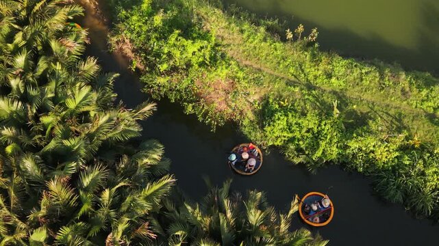 Aerial View Asian Tourists Hoian Lagoon. Couples And Friends Relax In Round Coracles Passing Sunlit Palm Stands, Shimmering Water, Warm Golden Tone, Carefree Travel Scene