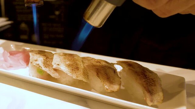Professional Chef Searing Aburi Sushi with Blue Flame Blowtorch in Japan