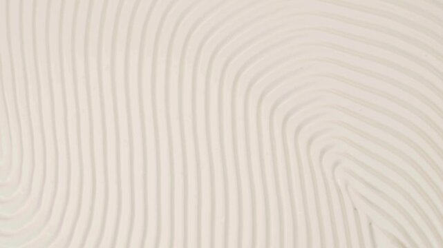 Close-up abstract pattern of parallel curved lines in soft neutral colors