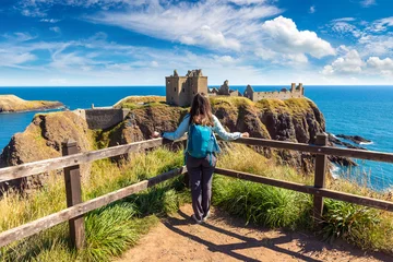Female hiker at Dunnottar Castle ruins on sea cliffs near Stonehaven, Aberdeenshire, Scotland, UK © Sergii Figurnyi