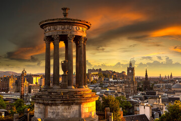 Naklejka premium Dugald Stewart Monument with Edinburgh cityscape and castle at sunset from Calton Hill in Edinburgh, Scotland, UK