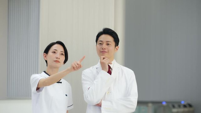 画面を見ながら相談する白衣の男女グループ