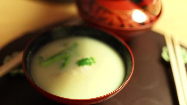 Hand Lifting Lid from Steaming Hot Japanese Miso Soup Bowl