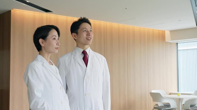 画面を見ながら会話する白衣の男女グループ