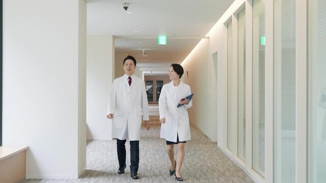 オフィスを歩く白衣の男女グループ