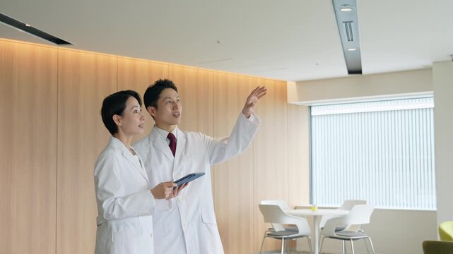 画面を見ながら会話する白衣の男女グループ