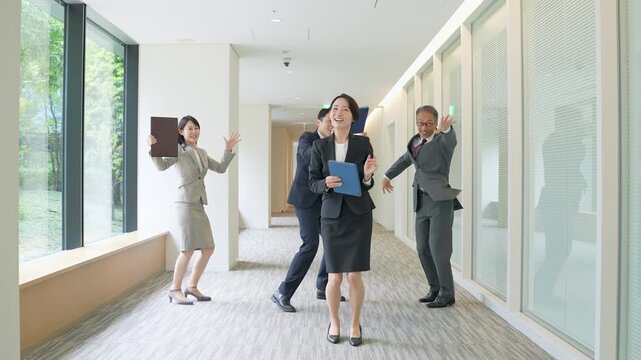 オフィスでダンスする男女ビジネスパーソンのグループ