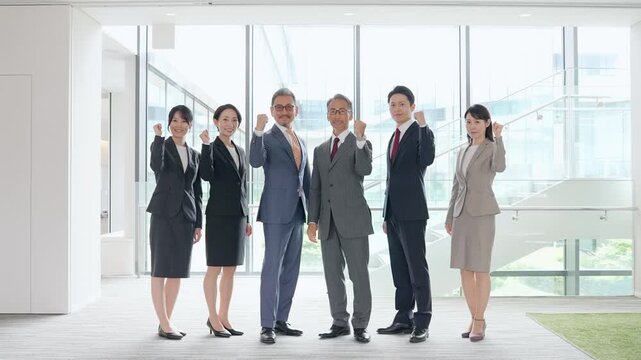 オフィスでガッツポーズするビジネスパーソンのグループ