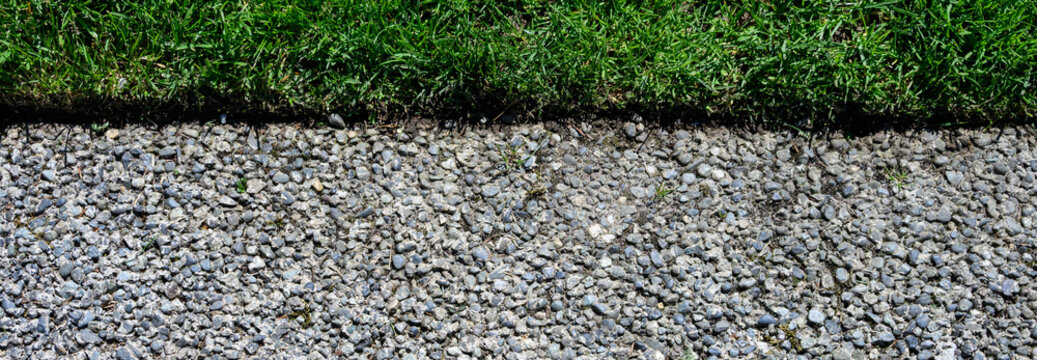 Pervious concrete, porous or permeable concrete, eco-friendly sidewalk in a public park bordering grass lawn
