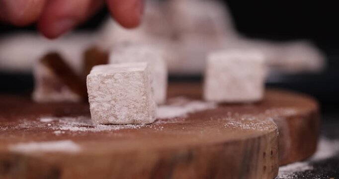 soft and fresh Turkish delight sprinkled with white sugar, cubic sweet white soft pieces of Turkish delight with nuts and dried fruits inside, closeup