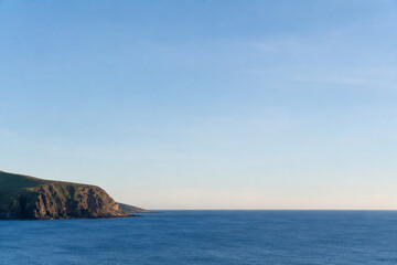 Naklejka premium Ultra Realistic Distant Coastal Cliff Meeting Calm Ocean Horizon