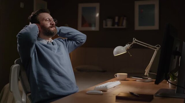Male freelancer rejoices at his success and leans back in his chair. Success, triumph concept