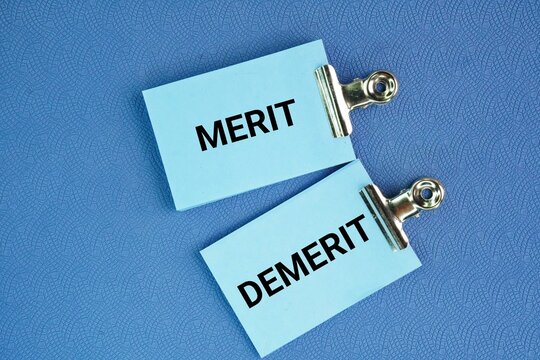 Blue paper with the words Merit and Demerit. noun. a quality deserving blame. Merit, demerit and its retributions at the level of the individual.