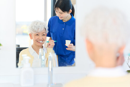 歯磨きをするシニアをサポートする介護士