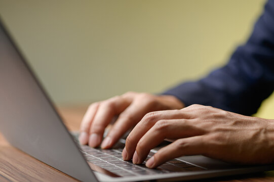 Close-Up of Hands Typing on Laptop Keyboard in Modern Workspace