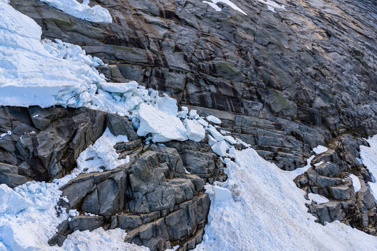 Blue Glacier Ice And Jagged Rock Face On Alpine Slope In BC, Canada
