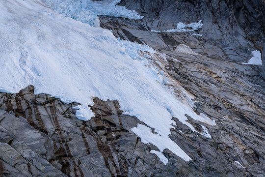 Blue Glacier Ice And Jagged Rock Face On Alpine Slope In BC, Canada