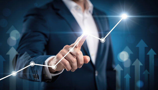 Businessman touching upward trending graph on digital interface showing business growth and success