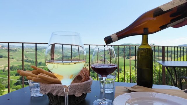 Pouring Red Wine on a Sunny Terrace Overlooking Italian Vineyards