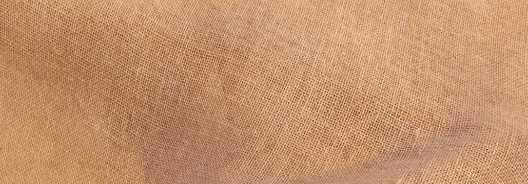 Close-up of rustic textured fabric. Brown burlap cloth background or sack cloth for packing